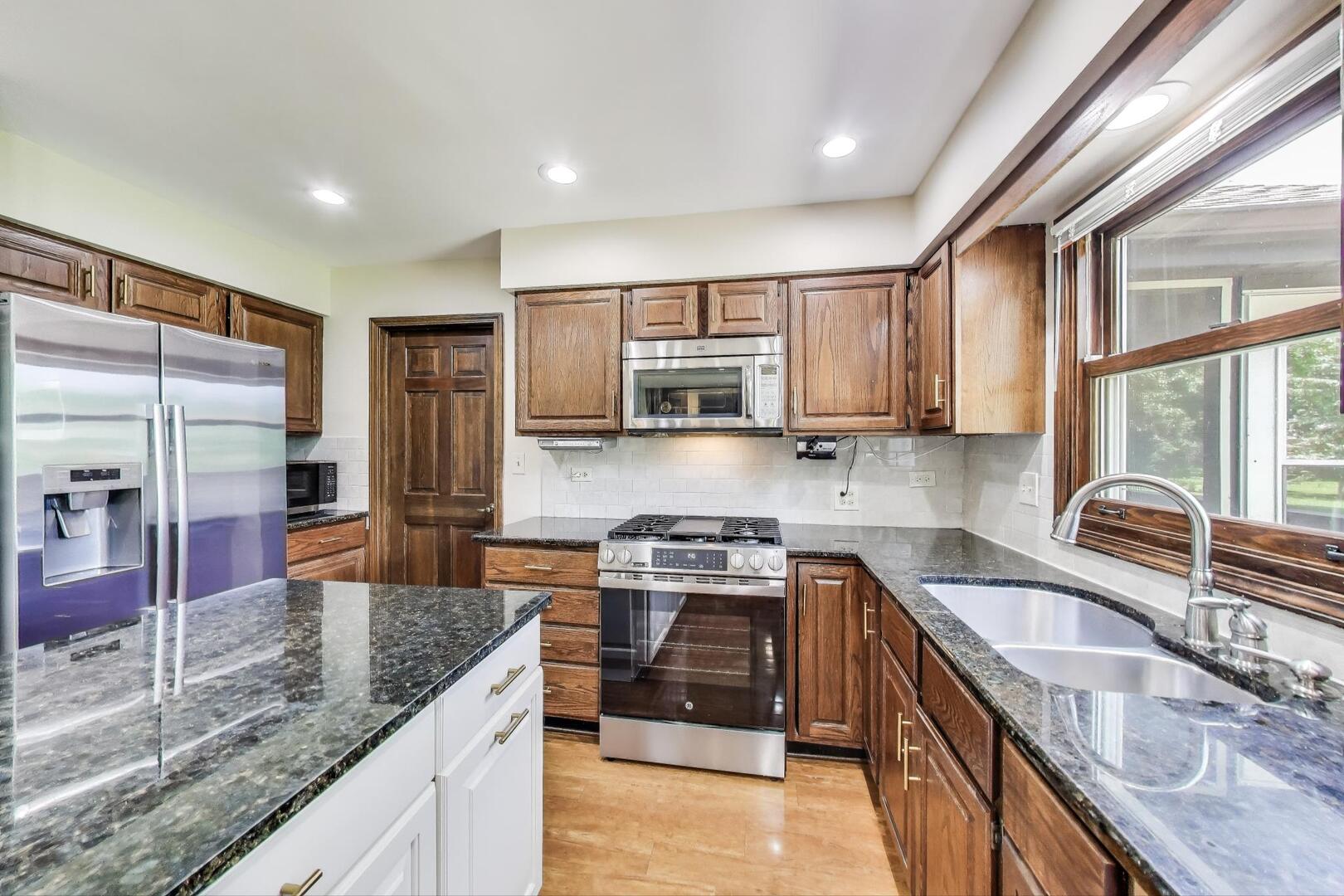 829 Shiloh Circle Naperville, IL 60540 - Photo 3 of 40 a kitchen with stainless steel appliances granite countertop a sink stove and refrigerator