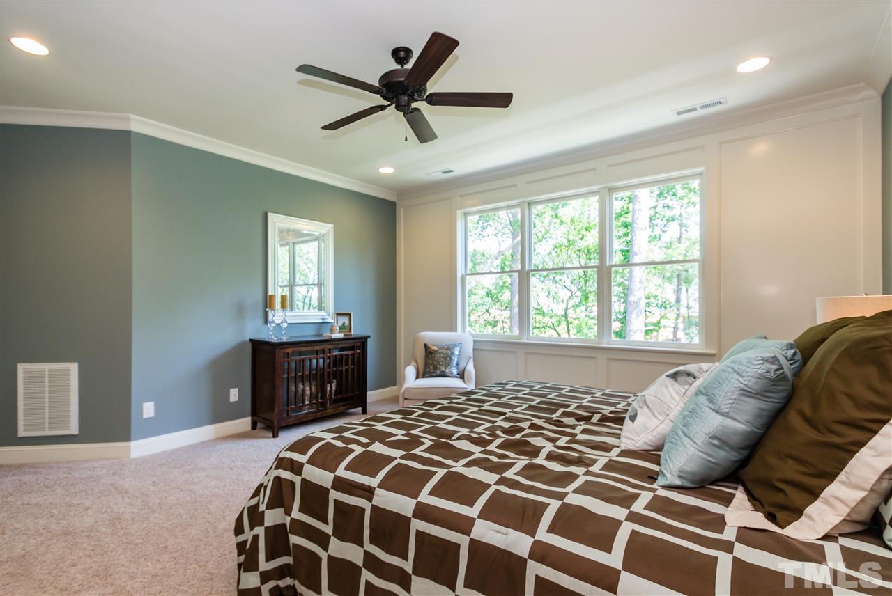 5208 Woodall Way, Unit 11 Raleigh, NC 27613 - Photo 14 of 25 a bedroom with a large bed and a chandelier