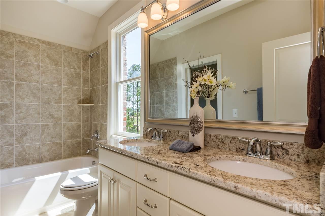 5208 Woodall Way, Unit 11 Raleigh, NC 27613 - Photo 20 of 25 a bathroom with a granite countertop sink toilet and a mirror
