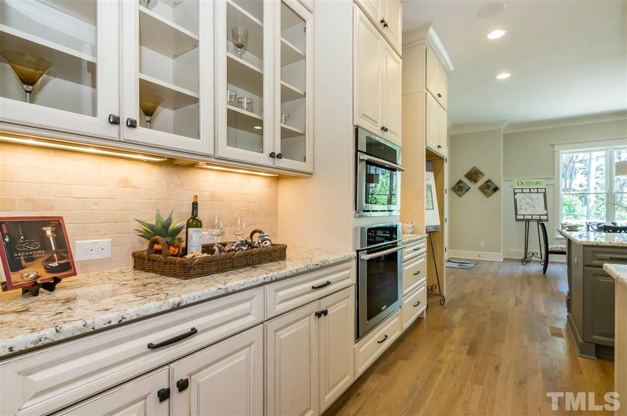 5208 Woodall Way, Unit 11 Raleigh, NC 27613 - Photo 8 of 25 a kitchen with stainless steel appliances lots of counter top space and wooden floor