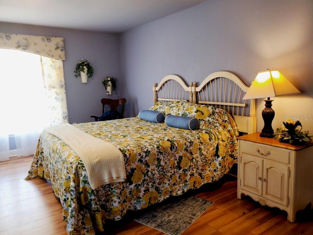 Undisclosed Address Umatilla, FL 32784 - Photo 2 of 9 a bedroom with a bed and wooden floor