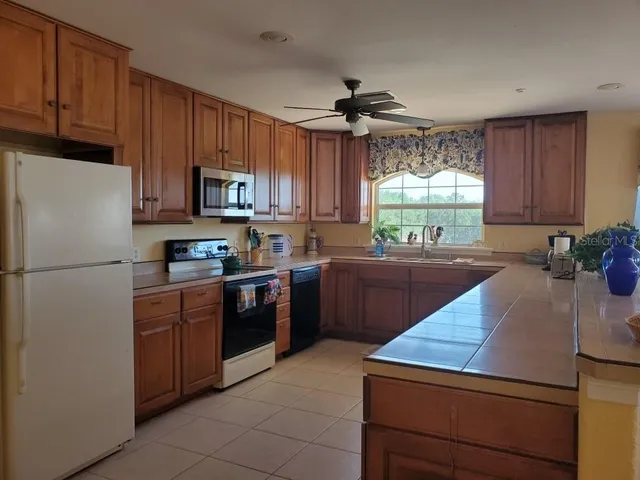 a kitchen with stainless steel appliances granite countertop a stove a sink and a refrigerator