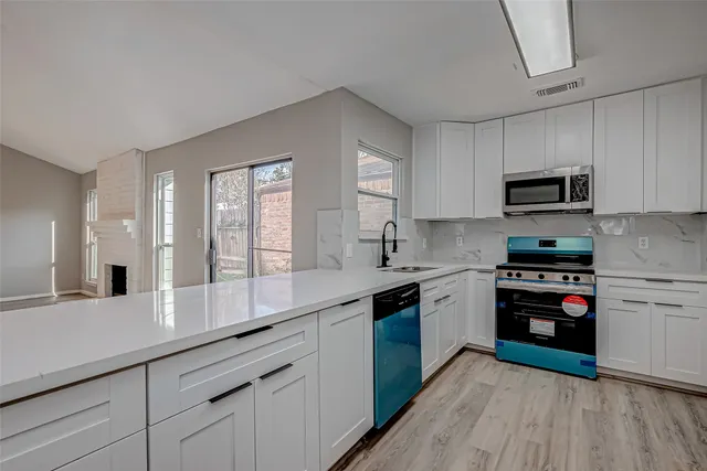 a kitchen with stainless steel appliances white cabinets and a sink