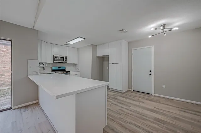 a view of cabinets with wooden floor and white walls
