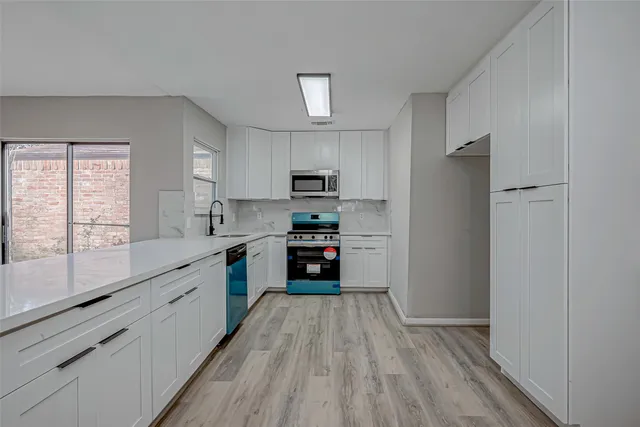 a kitchen with stainless steel appliances granite countertop a stove a sink and a microwave