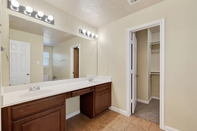 a bathroom with a double vanity sink a mirror and a bathtub