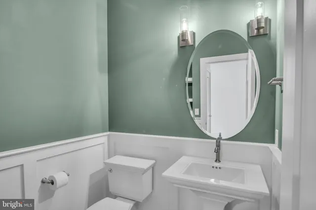 a bathroom with a sink toilet and mirror