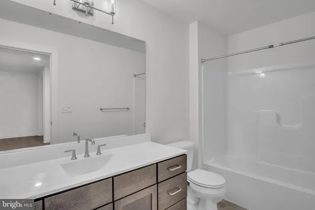 a bathroom with a sink toilet vanity and shower
