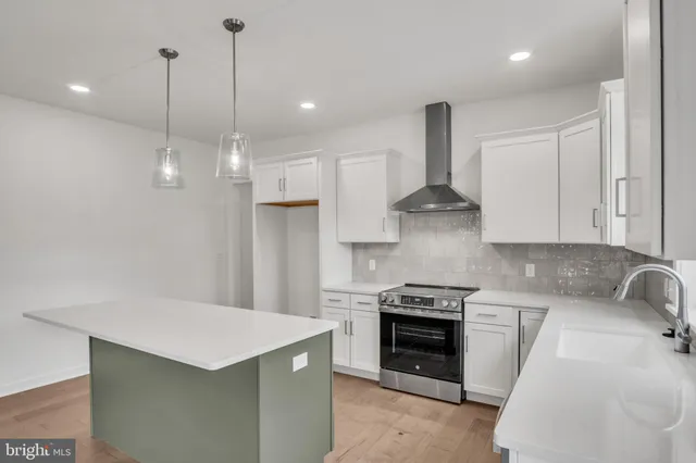 a kitchen with stainless steel appliances granite countertop a sink a stove and a refrigerator