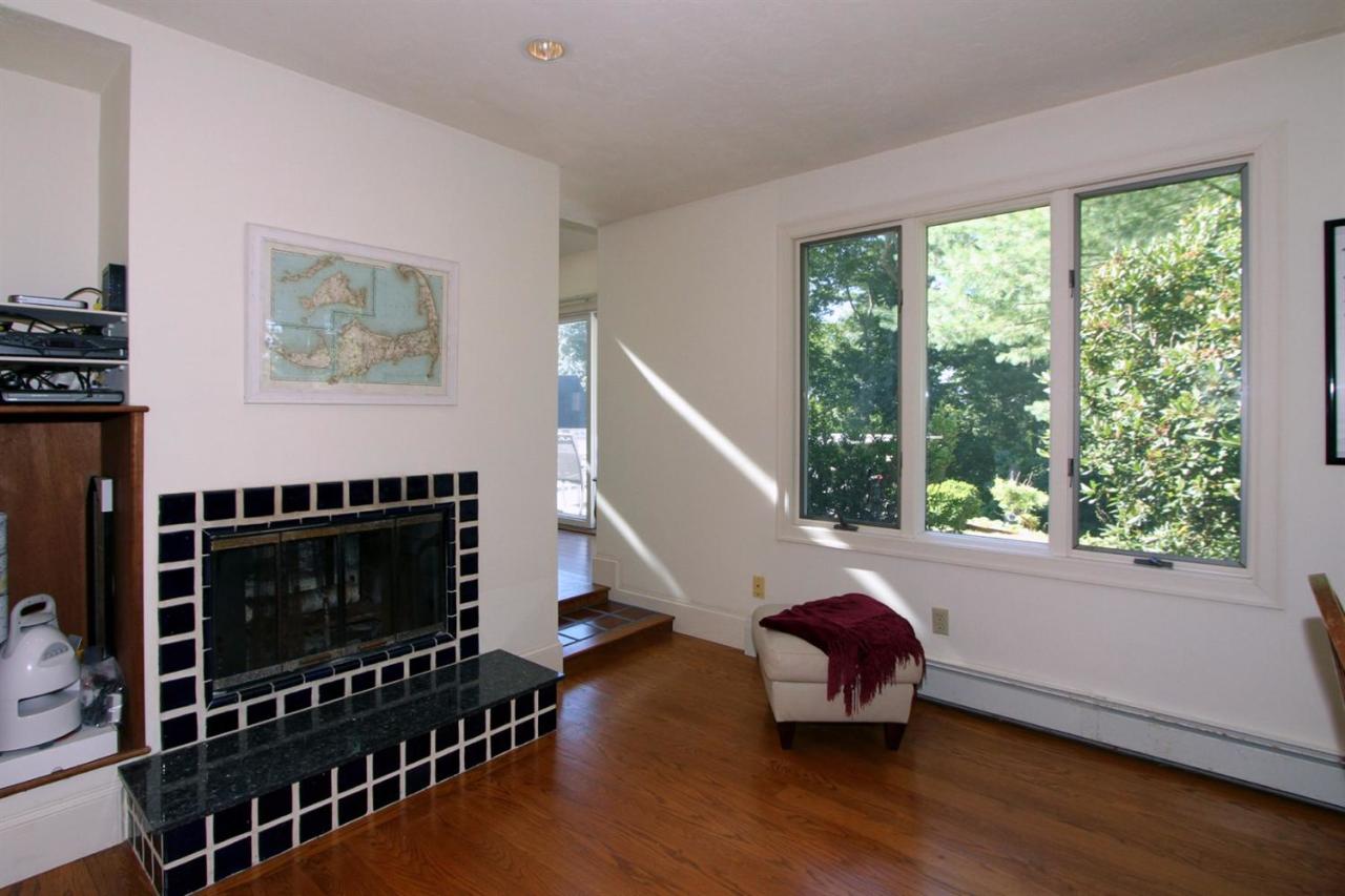 118 Elgin Road Pocasset, MA 02559 - Photo 15 of 35 a living room with furniture a fireplace and a floor to ceiling window