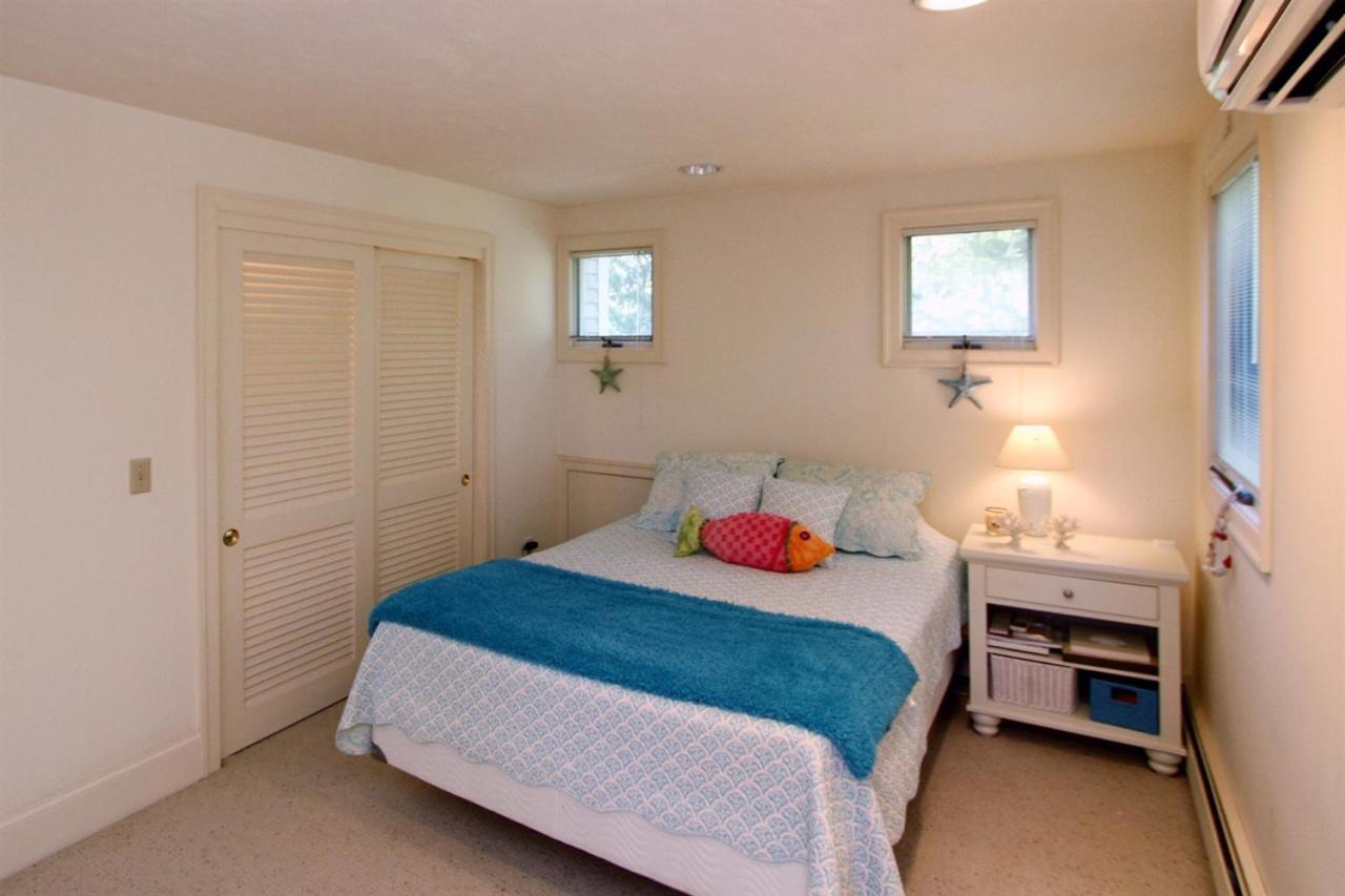 118 Elgin Road Pocasset, MA 02559 - Photo 24 of 35 a bedroom with a bed and a lamp