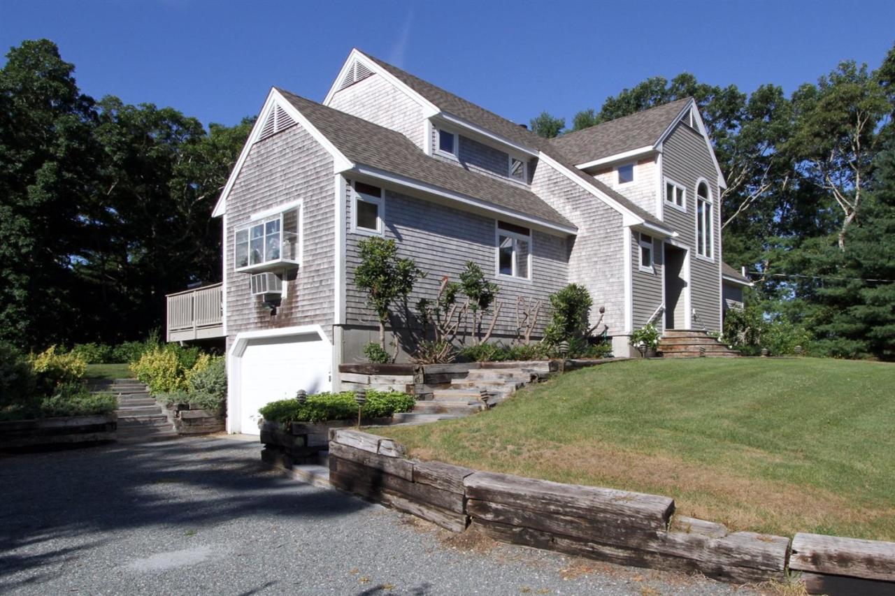 118 Elgin Road Pocasset, MA 02559 - Photo 3 of 35 a view of a white house next to a yard with potted plants