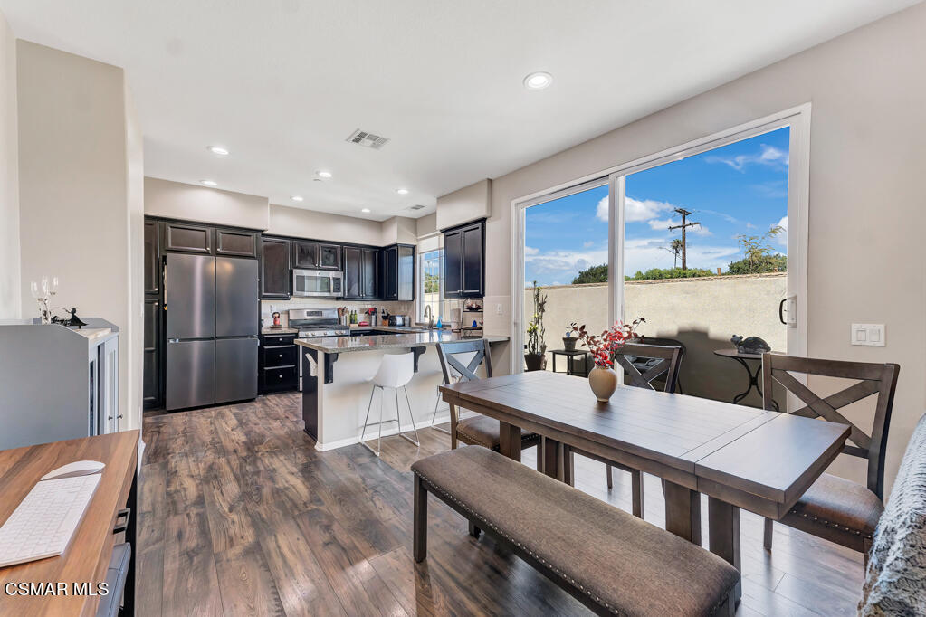 443 Stratus Lane, Unit 3 Simi Valley, CA 93065 - Photo 11 of 41 a kitchen with a table chairs refrigerator and cabinets