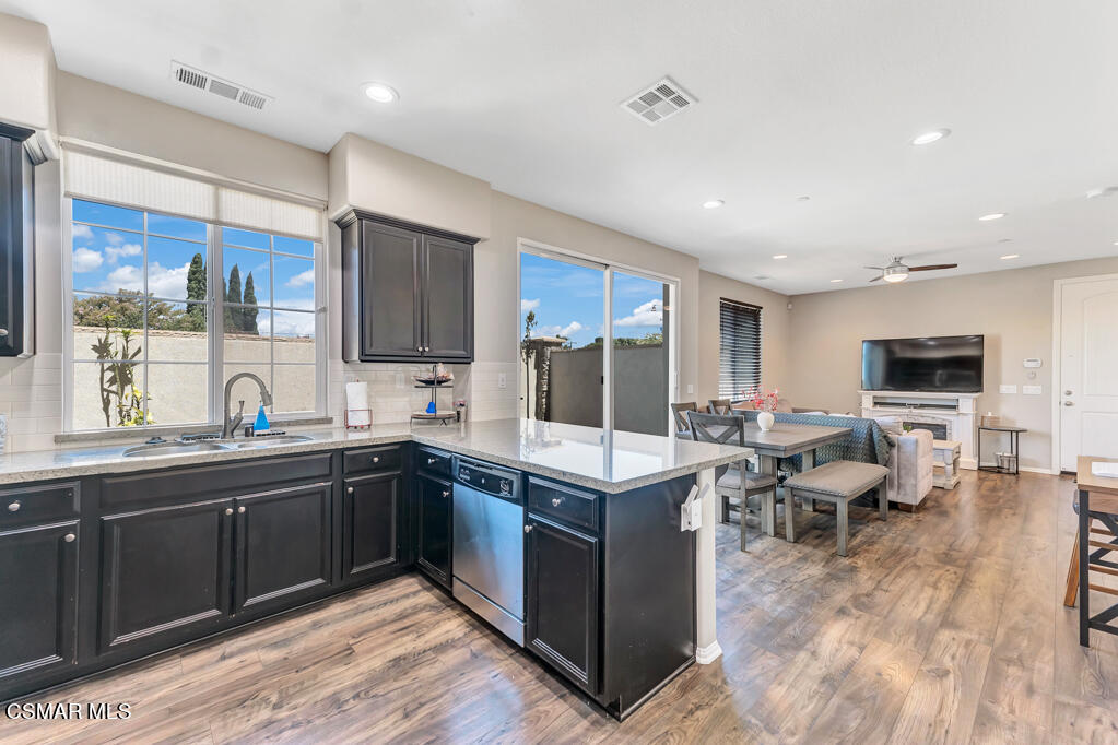 443 Stratus Lane, Unit 3 Simi Valley, CA 93065 - Photo 12 of 41 a kitchen with stainless steel appliances granite countertop a sink dishwasher stove and wooden cabinets