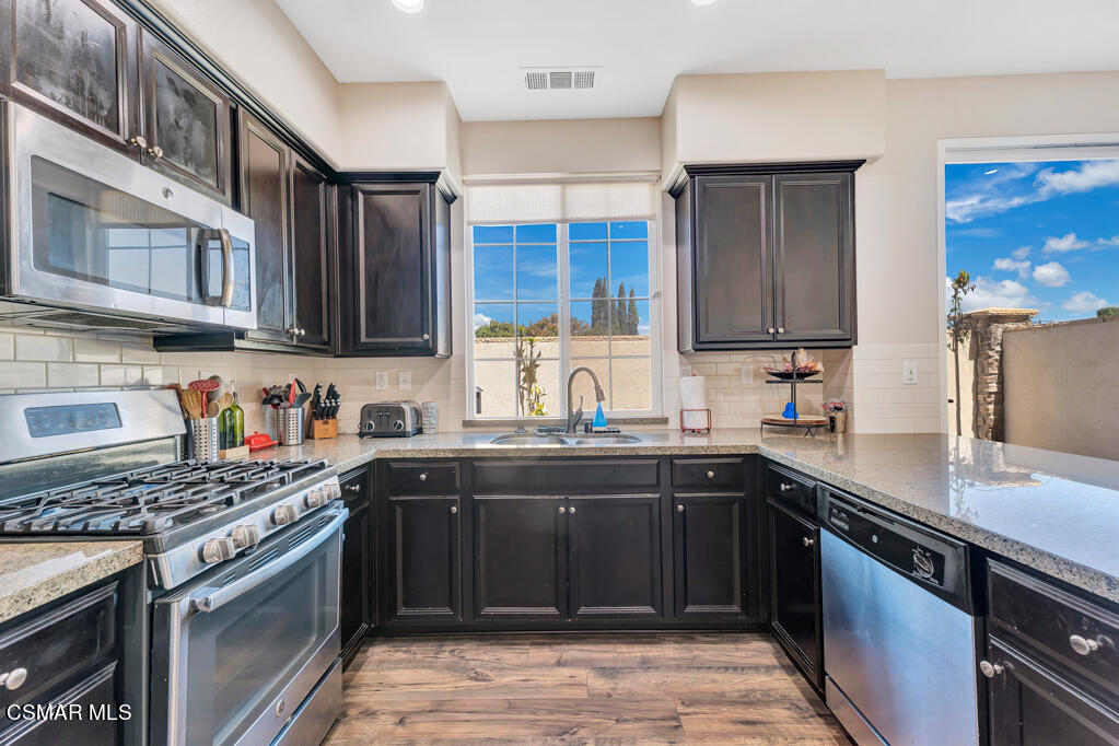 443 Stratus Lane, Unit 3 Simi Valley, CA 93065 - Photo 16 of 41 a kitchen with stainless steel appliances granite countertop a sink stove and cabinets