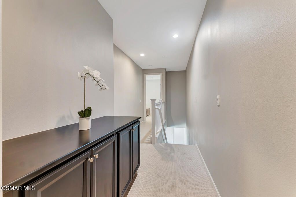443 Stratus Lane, Unit 3 Simi Valley, CA 93065 - Photo 20 of 41 a hallway with a sink a mirror and wooden floor