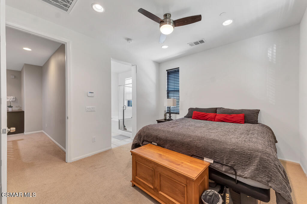 443 Stratus Lane, Unit 3 Simi Valley, CA 93065 - Photo 26 of 41 a bedroom with a bed and a chandelier