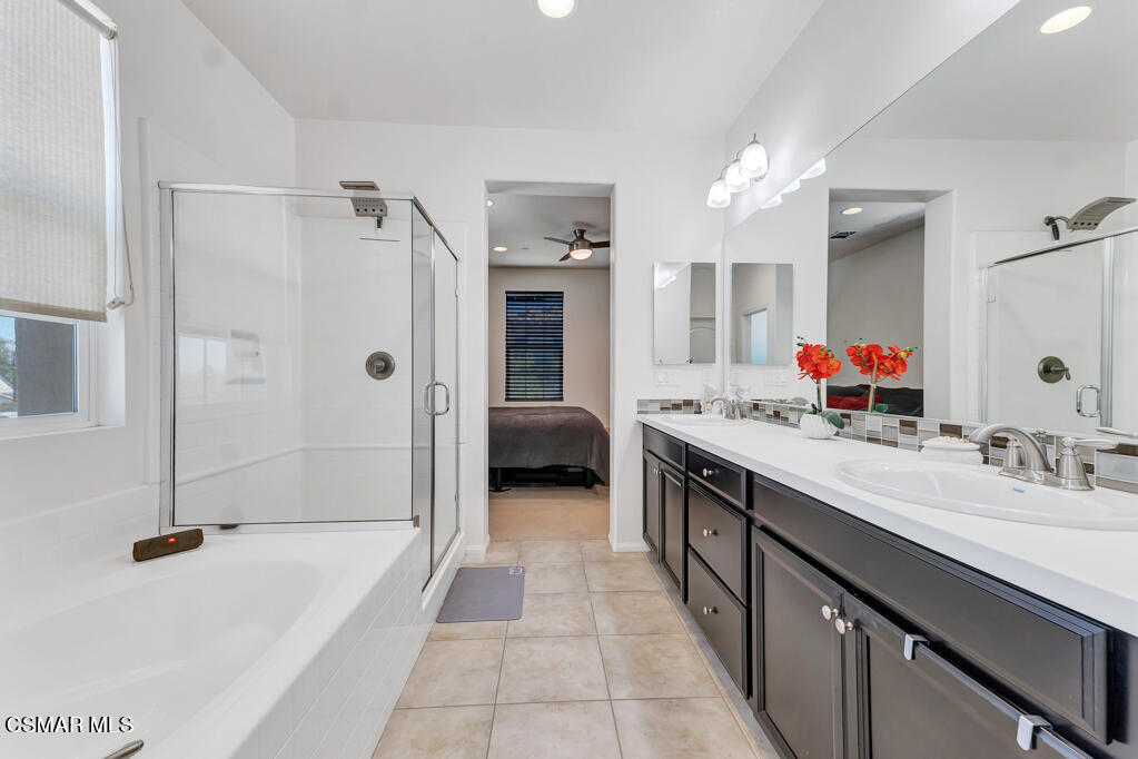 443 Stratus Lane, Unit 3 Simi Valley, CA 93065 - Photo 38 of 41 a spacious en suite bathroom with a double vanity sink a mirror a bathtub and shower