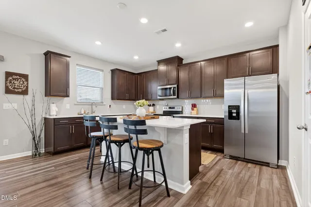 a kitchen with a refrigerator a sink and cabinets