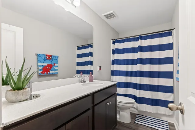 a bathroom with a sink a toilet and a shower