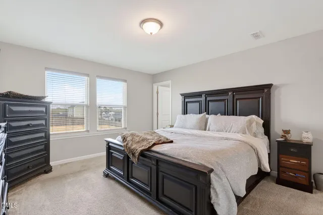 a bed sitting in a bedroom next to a window
