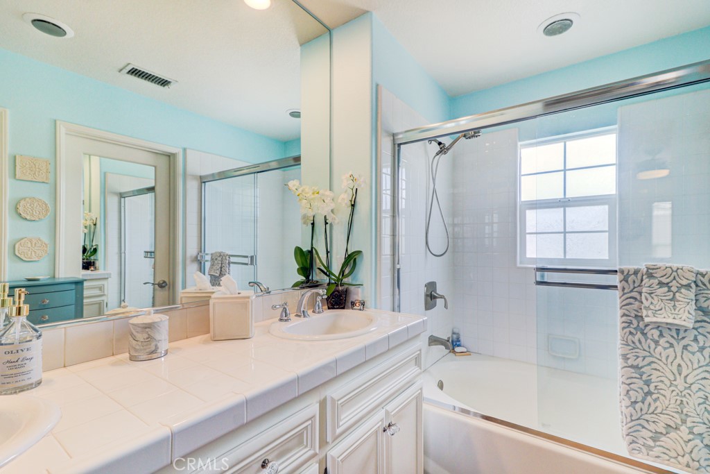 1 Agave Court Ladera Ranch, CA 92694 - Photo 17 of 23 a bathroom with a granite countertop sink a mirror a bathtub and shower