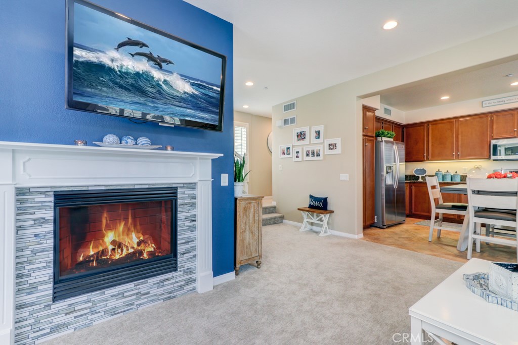 1 Agave Court Ladera Ranch, CA 92694 - Photo 6 of 23 a living room with furniture a fireplace and kitchen view