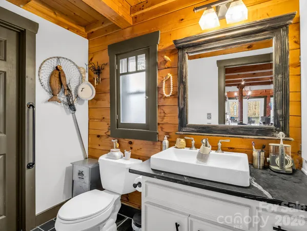 a bathroom with a granite countertop sink and a large mirror