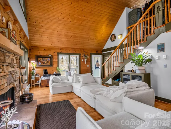 a living room with furniture stairs and a flat screen tv