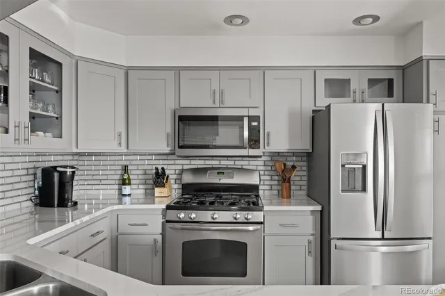 a kitchen with stainless steel appliances a sink stove and cabinets