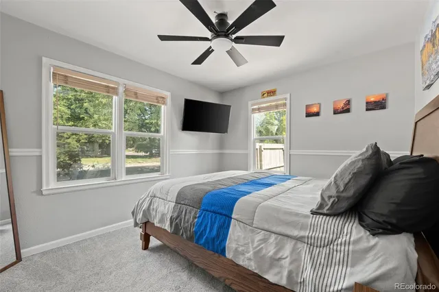 a bedroom with a bed and painting on the wall