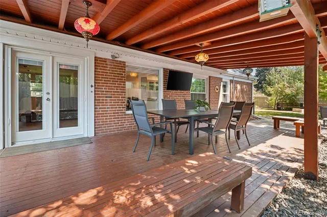 a patio with a table and chairs and potted plants