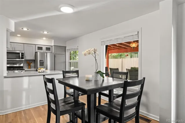 a kitchen with stainless steel appliances a dining table chairs stove and cabinets