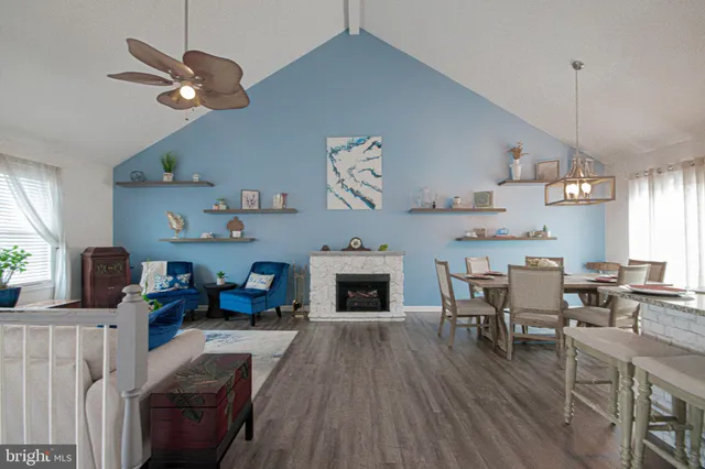 a view of a dining room with furniture a fireplace and wooden floor