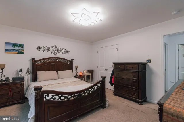 a large bed sitting in a bedroom next to a window and a chandelier