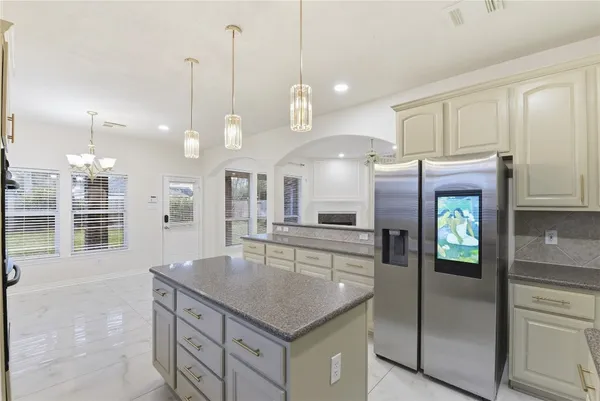a kitchen with stainless steel appliances granite countertop a refrigerator a sink and a stove