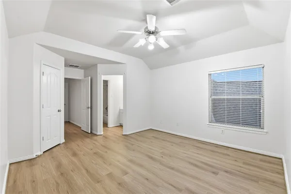 a view of wooden floor and a chandelier fan in a room