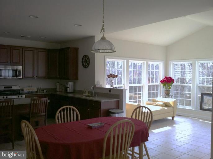 4279 Meyers Road Triangle, VA 22172 - Photo 16 of 24 a kitchen with granite countertop a stove a sink dishwasher a dining table and chairs with wooden floor