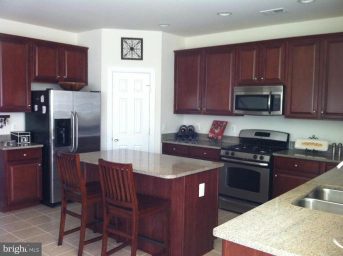 4279 Meyers Road Triangle, VA 22172 - Photo 6 of 24 a kitchen with a stove a sink and a microwave