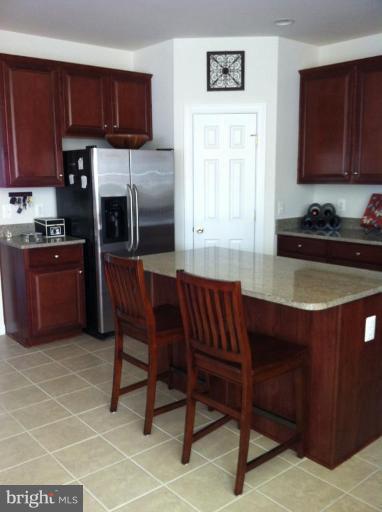 4279 Meyers Road Triangle, VA 22172 - Photo 7 of 24 a kitchen with stainless steel appliances granite countertop a sink wooden cabinets and a granite counter top