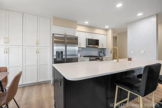 a kitchen with kitchen island a sink appliances and a counter top space