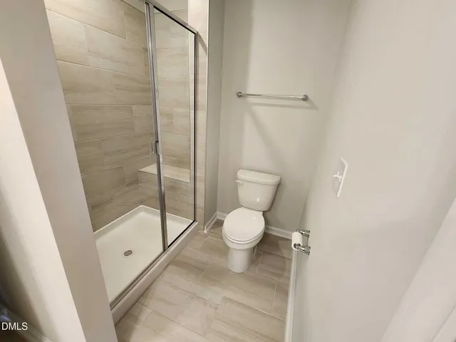 a bathroom with a sink a toilet a mirror and shower
