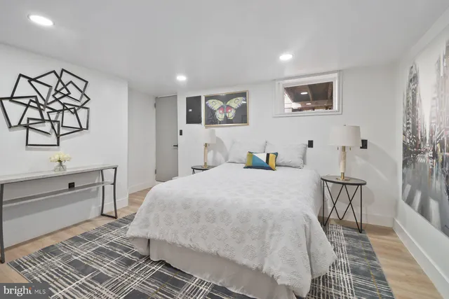 a bedroom with a bed and a table with wooden floor