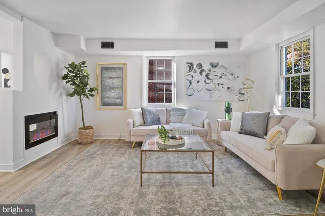 a living room with furniture a fireplace and a large window