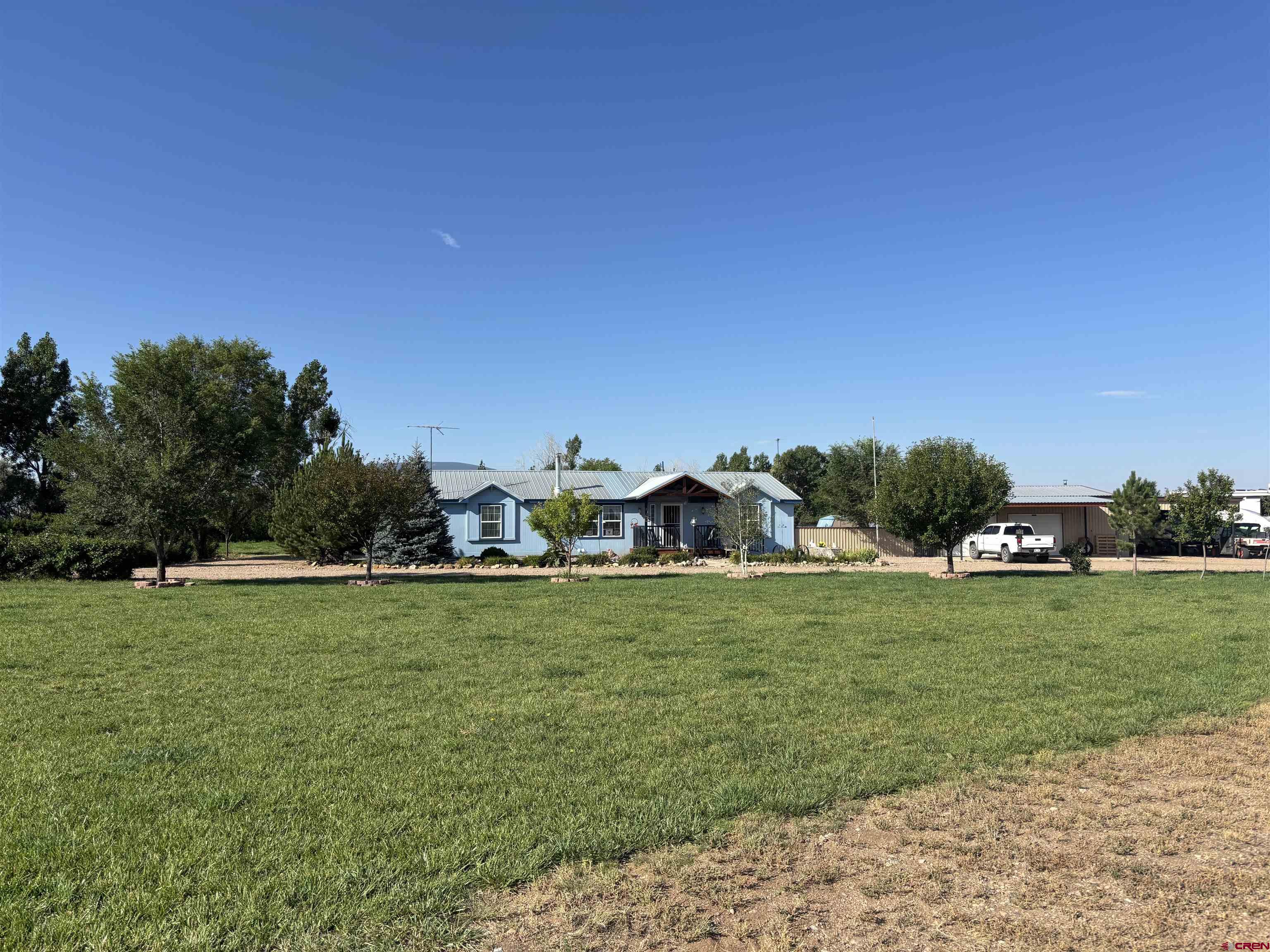 9227 County Rd C Jaroso, CO 81138 - Photo 18 of 28 a front view of a house with a yard and garage