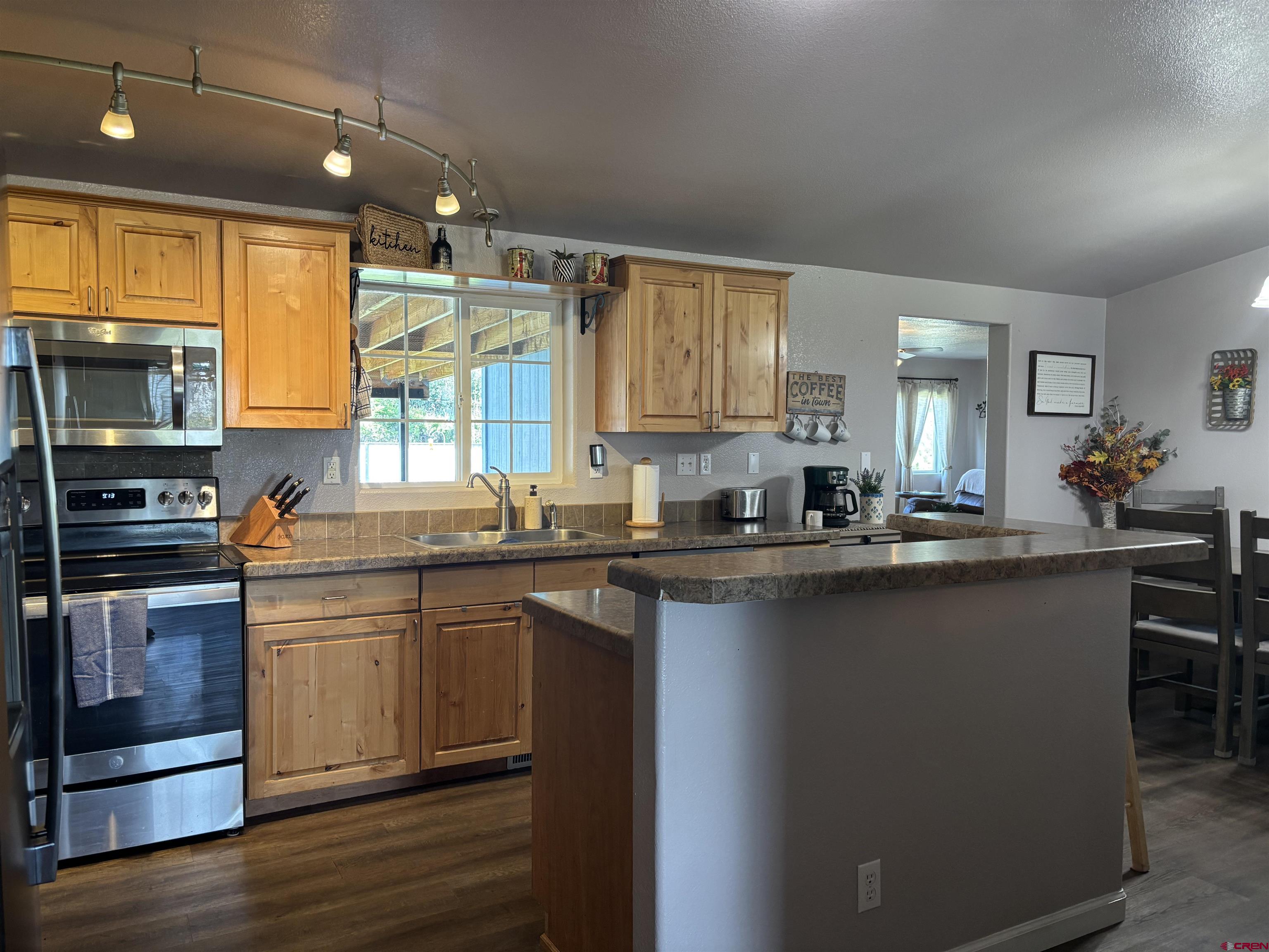9227 County Rd C Jaroso, CO 81138 - Photo 20 of 28 a kitchen with kitchen island granite countertop a sink cabinets and stainless steel appliances
