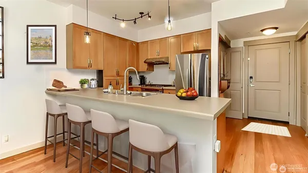 a kitchen with kitchen island granite countertop a sink cabinets and wooden floor