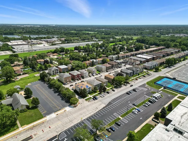 an aerial view of a city with lots of residential buildings and ocean view in back