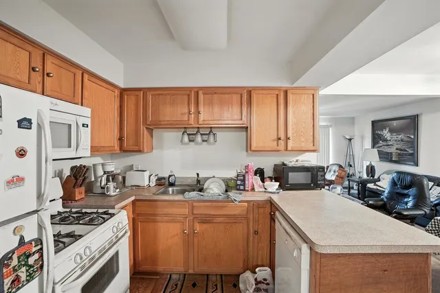 a kitchen with stainless steel appliances a stove a sink a cabinets and a refrigerator