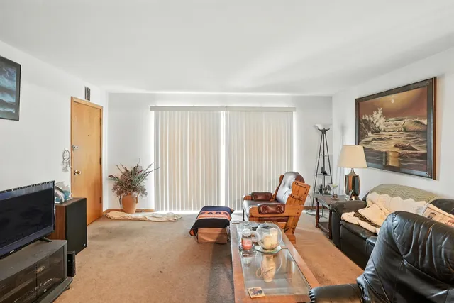 a living room with furniture a flat screen tv and a window